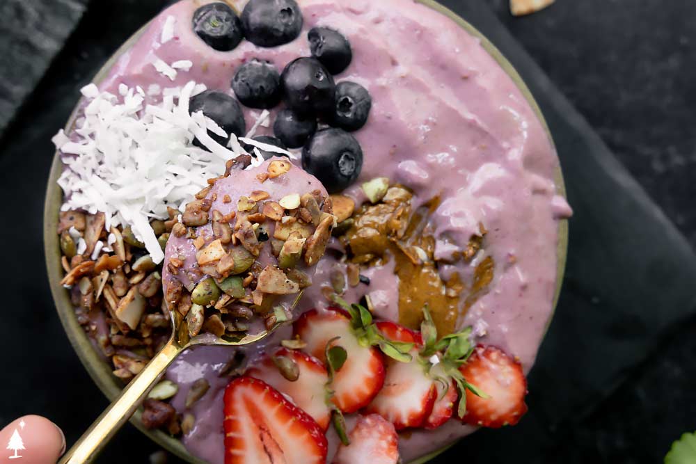 scooped Keto Berry smoothie bowl with berry toppings
