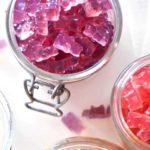 a jar of purple gummy bears with another jar of red gummy bears on the side