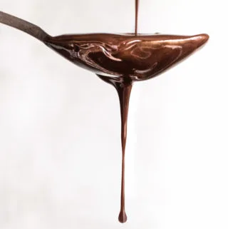 homemade sugar free chocolate syrup dripping off a spoon