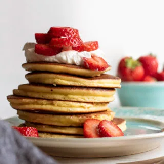 stack of low carb pancakes with low carb fruit and sugar free whipped cream on top