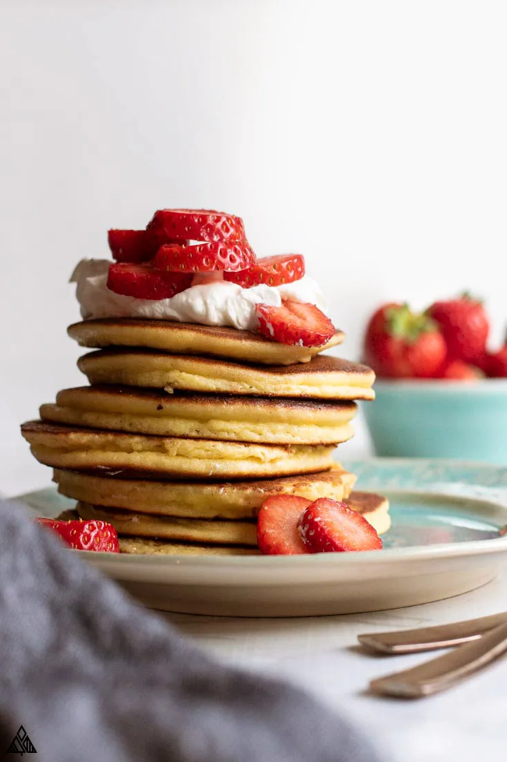 stack of low carb pancakes with low carb fruit and sugar free whipped cream on top