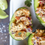 Halved avocado topped with mexican chicken salad