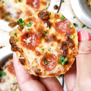 Hand holding a piece of cauliflower pizza bites