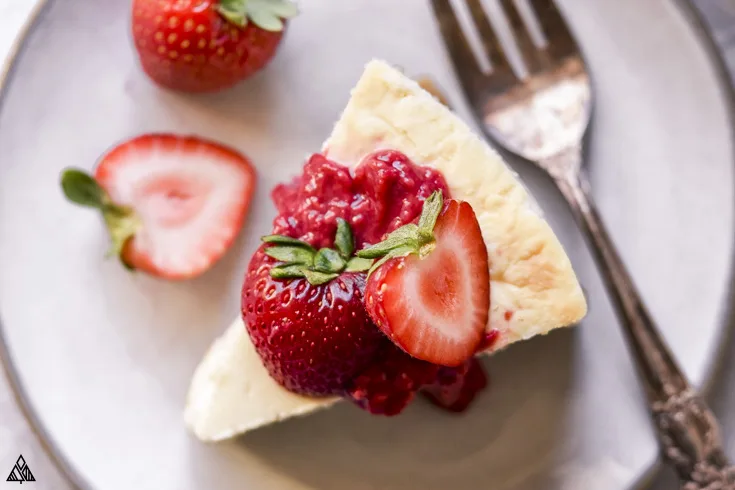 Slice of low carb cheesecake with strawberries on top