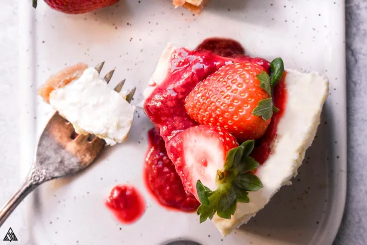 Slice of low carb cheesecake with strawberries on top