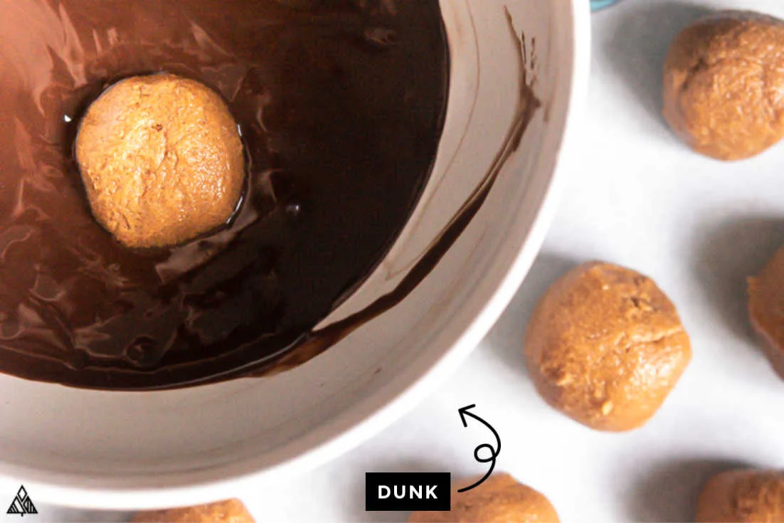 Low carb peanut butter balls dipped into a bowl of melted chocolate