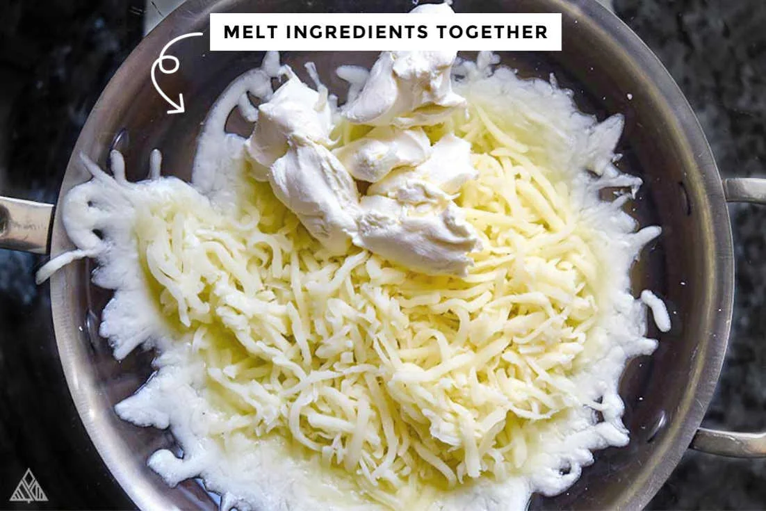 Melting the shredded cheese and cream cheese in a pan