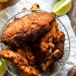 basket full of low carb fried chicken with limes and hot sauce