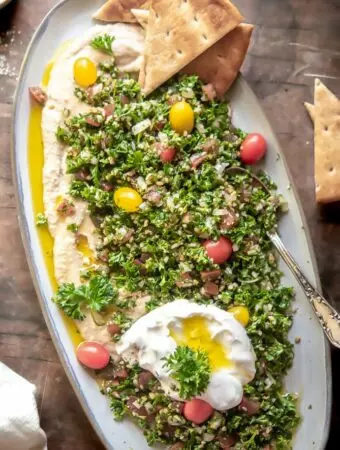 tabbouleh salad recipe on a platter with pita, labneh and hummus