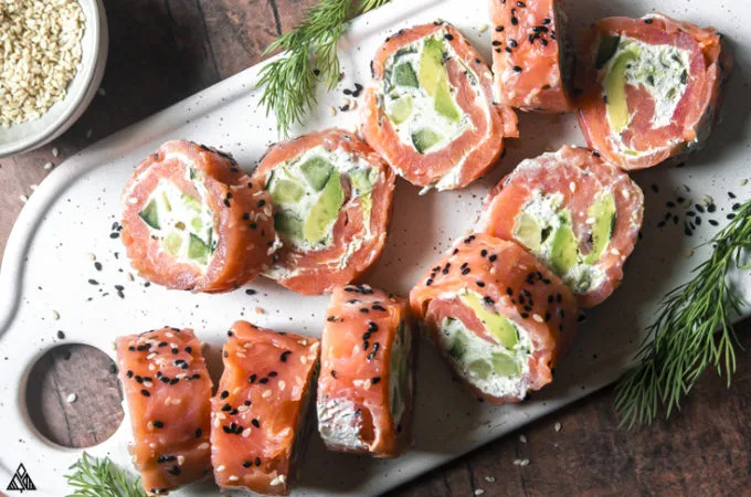 Slices of smoked salmon roll ups on a cutting board