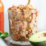 mexican chicken salad recipe in a cup with a spoon and avocado in front