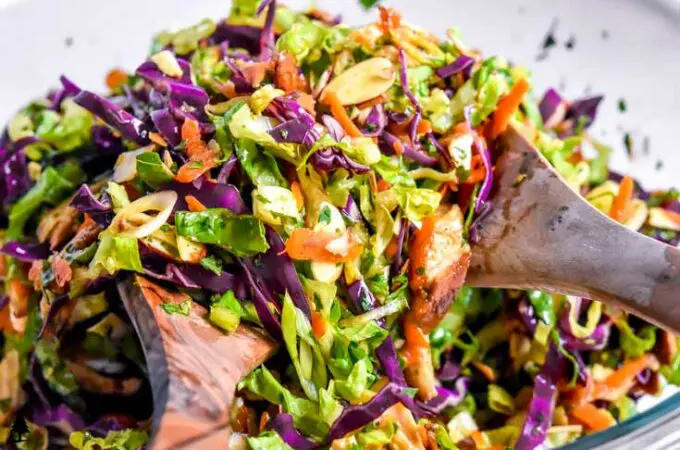 Chinese chicken salad being tossed with Asian dressing
