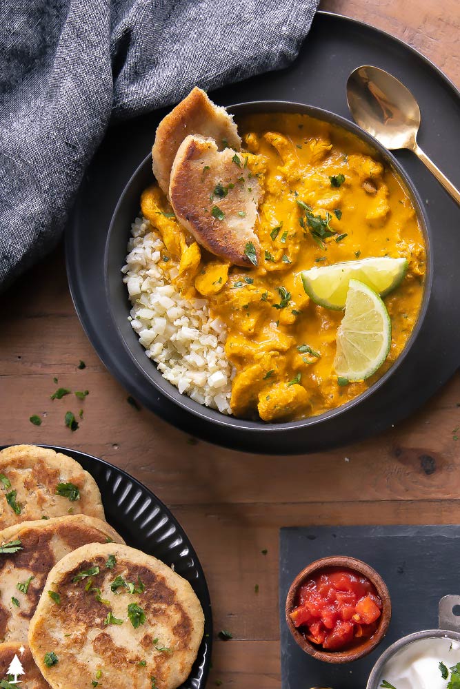 top view of indian chicken curry in a bowl with low carb naan