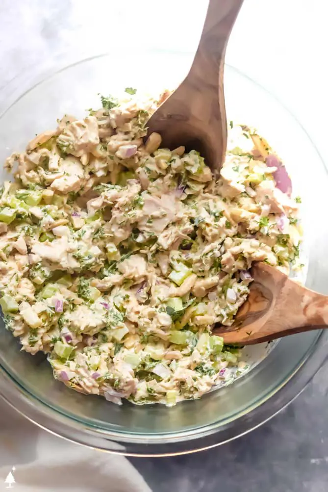 healthy chicken salad together in a bowl with 2 spoons