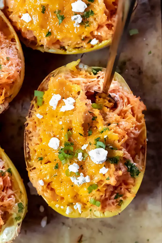 buffalo chicken spaghetti squash in a spaghetti squash boat with a fork