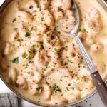 skillet with creamy garlic shrimp and a spoon