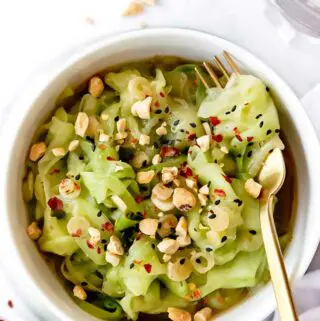 cucumber noodles recipe in a bowl with a fork and peanuts on top