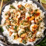 chimichurri shrimp on a plate with rice and limes