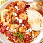 shrimp saganaki recipe in a bowl with bread and dill