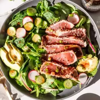 ahi tuna salad on a plate with avocado and greens