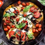caprese chicken recipe in a cast iron with balsamic reduction on top