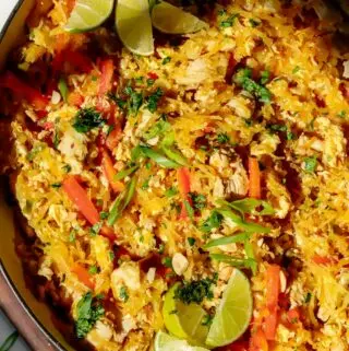 spaghetti squash pad thai in a pan with lime and cilantro on top