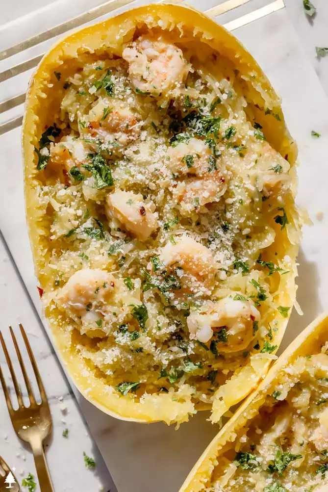 spaghetti squash shrimp scampi boat on a marble cutting board with a fork