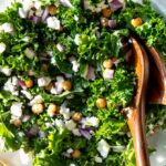 kale salad recipe in a bowl with chicken peas and feta on top