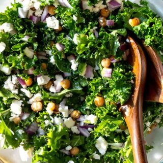 kale salad recipe in a bowl with chicken peas and feta on top