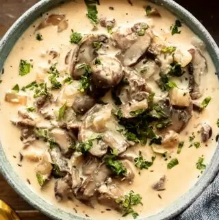 mushroom soup recipe in a bowl with parsley and mushrooms on top
