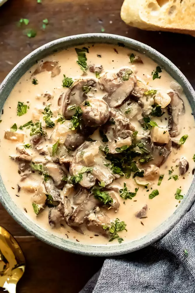 mushroom soup recipe in a bowl with parsley and mushrooms on top