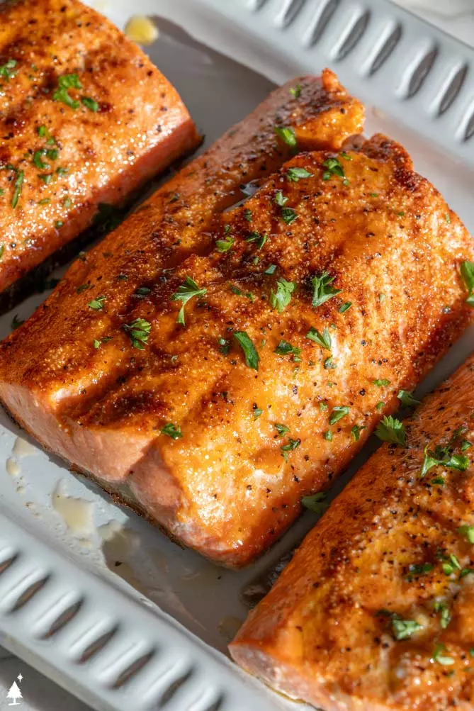 broiling salmon on a platter with parsley
