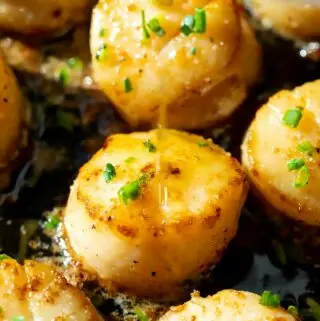 seared scallops recipe in a pan, with lemon butter drizzled on top