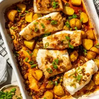 chilean sea bass recipe in a baking dish with potatoes and green onions on top