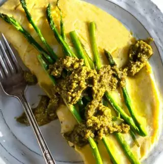 asparagus omelette on a plate with pesto on top