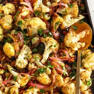 curried cauliflower recipe on a baking sheet with a spoon
