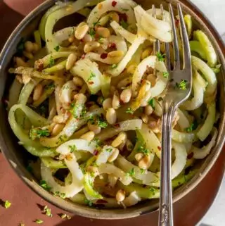 simple kohlrabi recipe for kohlrabi noodles in a bowl with pine nuts on top