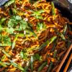 sweet potato noodles in a skillet with chopsticks