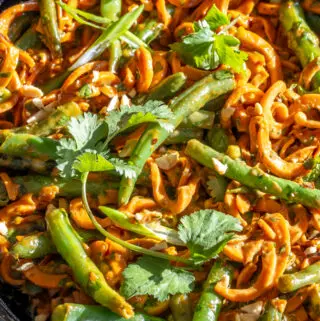 yam noodles in a skillet with herbs and green beans