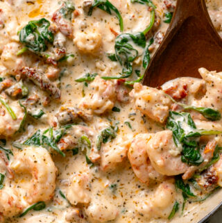 tuscan shrimp recipe in a pan with a spoon