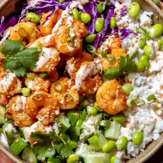 shrimp poke bowl recipe with rice, edamame, cabbage and sauce