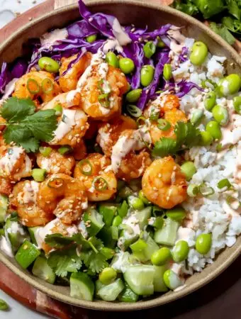 shrimp poke bowl recipe with rice, edamame, cabbage and sauce