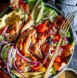 honey mustard chicken salad in a blue bowl with avocado and bacon