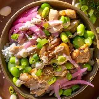 chicken poke bowl recipe with edamame, sauce, and pickled onions in a bowl